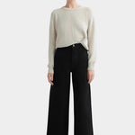 Kowtow Sailor Jeans in black worn with cream knit sweater, full length front view