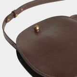 Chaga Eggi leather bag laid flat, showing its curved profile, gusset, and adjustable shoulder strap