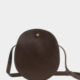 Front view of the LINDQUIST Eggi leather bag in Chaga with an oval silhouette and brass closure, at YUCCA Denver