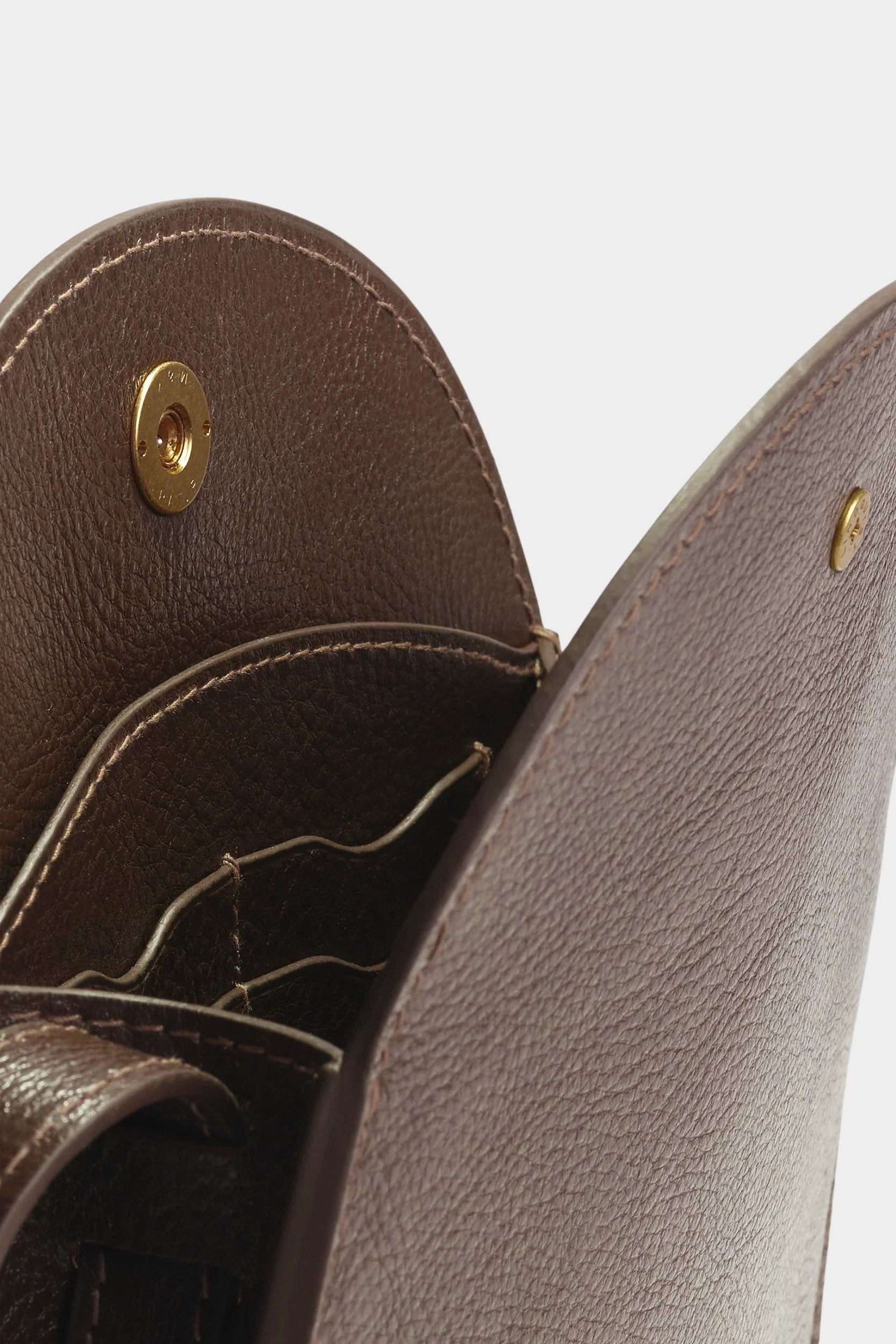Open Chaga Eggi bag showing its interior leather card pockets, divided compartments, and brass snap