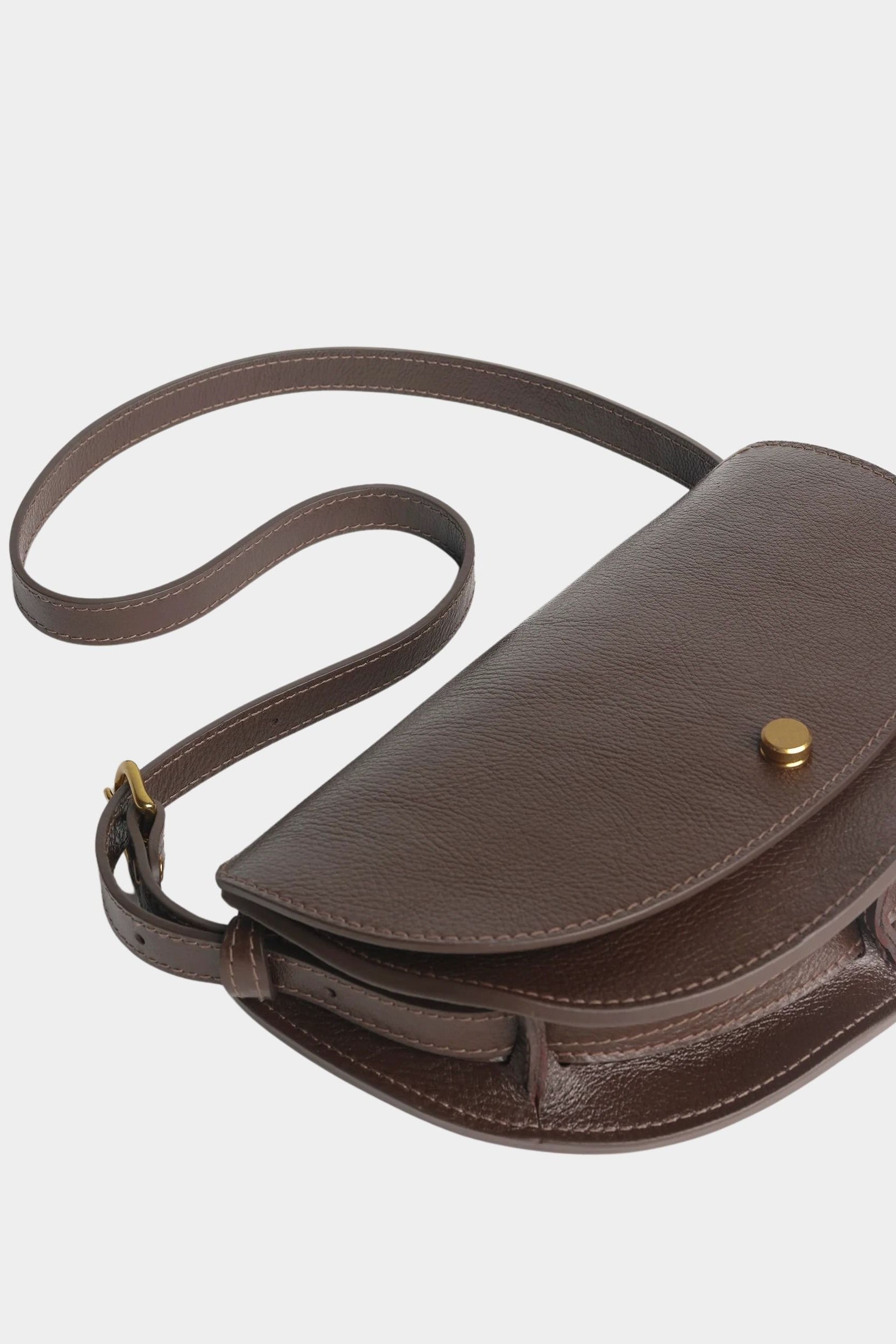 LINDQUIST Mezzo bag in Chaga laid flat with its leather strap curled beside the crescent body