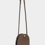 Mini Eggi leather crossbody bag in Chaga with its adjustable strap extended, offered at YUCCA in Denver