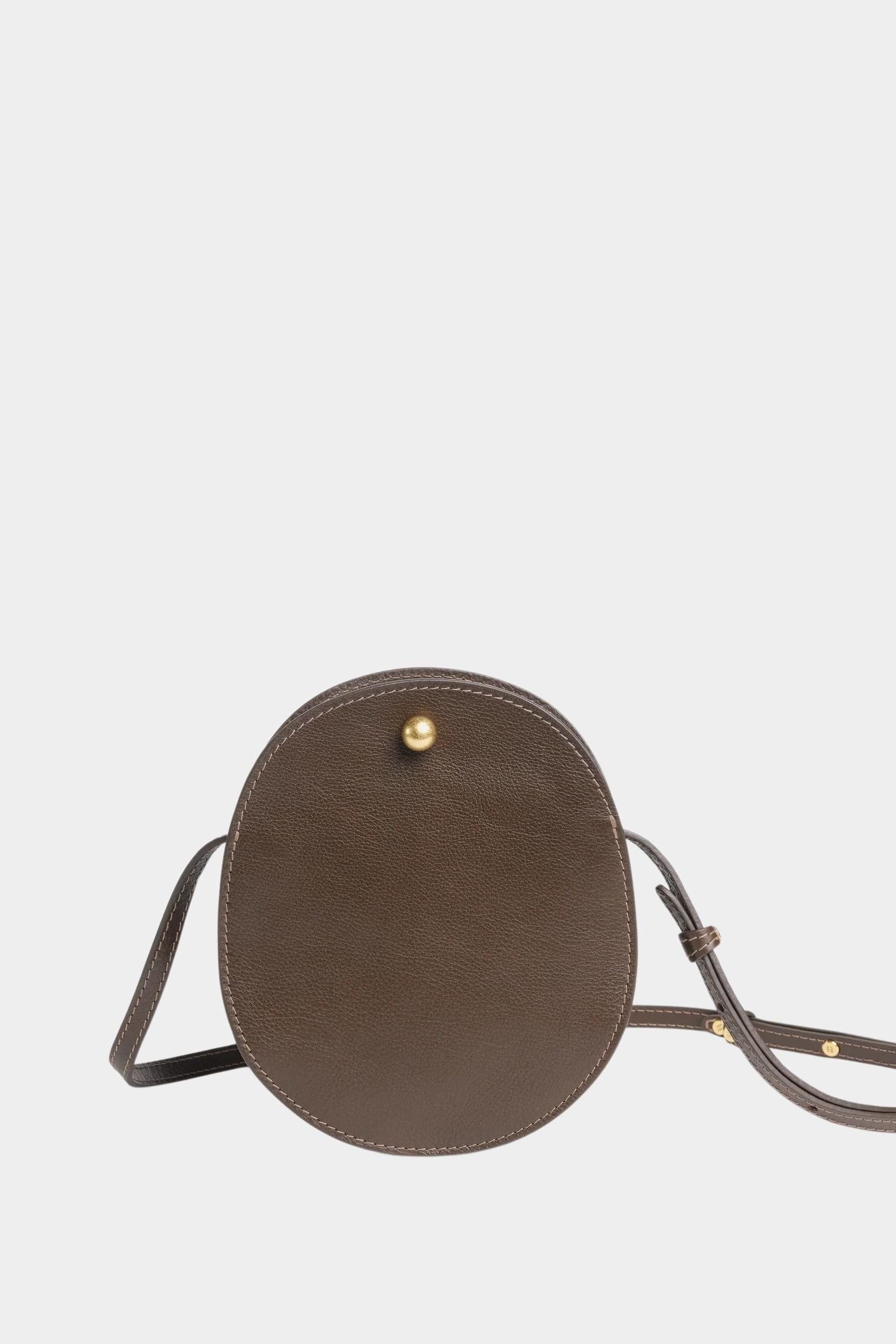 Front view of the Chaga Mini Eggi bag with its adjustable leather strap arranged around the base