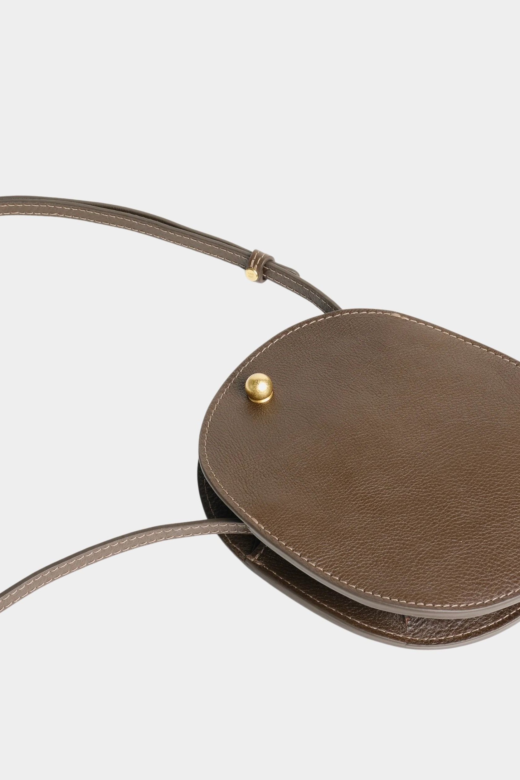 LINDQUIST Mini Eggi bag in Chaga laid flat, showing its oval shape, side gusset, and slim leather strap