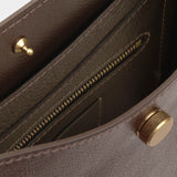Close view of the Chaga Savoie bag’s interior zippered pocket, pebbled leather, and brass closure