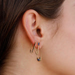 Loren Stewart Cirque Safety Pin Earring in 14k gold worn below two delicate gold earrings