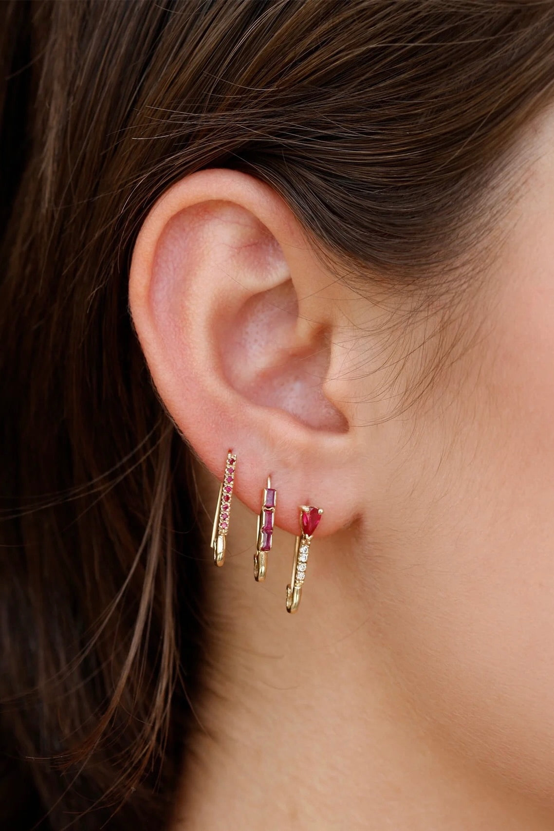 Mini Ruby Diamond Safety Pin Earring in 14k gold worn with two ruby safety pin earrings