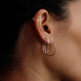 Loren Stewart sterling silver Safety Pin Earring styled with silver hoops on the ear at YUCCA Denver.