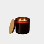Los Poblanos Vela de la Alhucema Lavender Candle burning in amber glass vessel with wooden lid, lifestyle product image