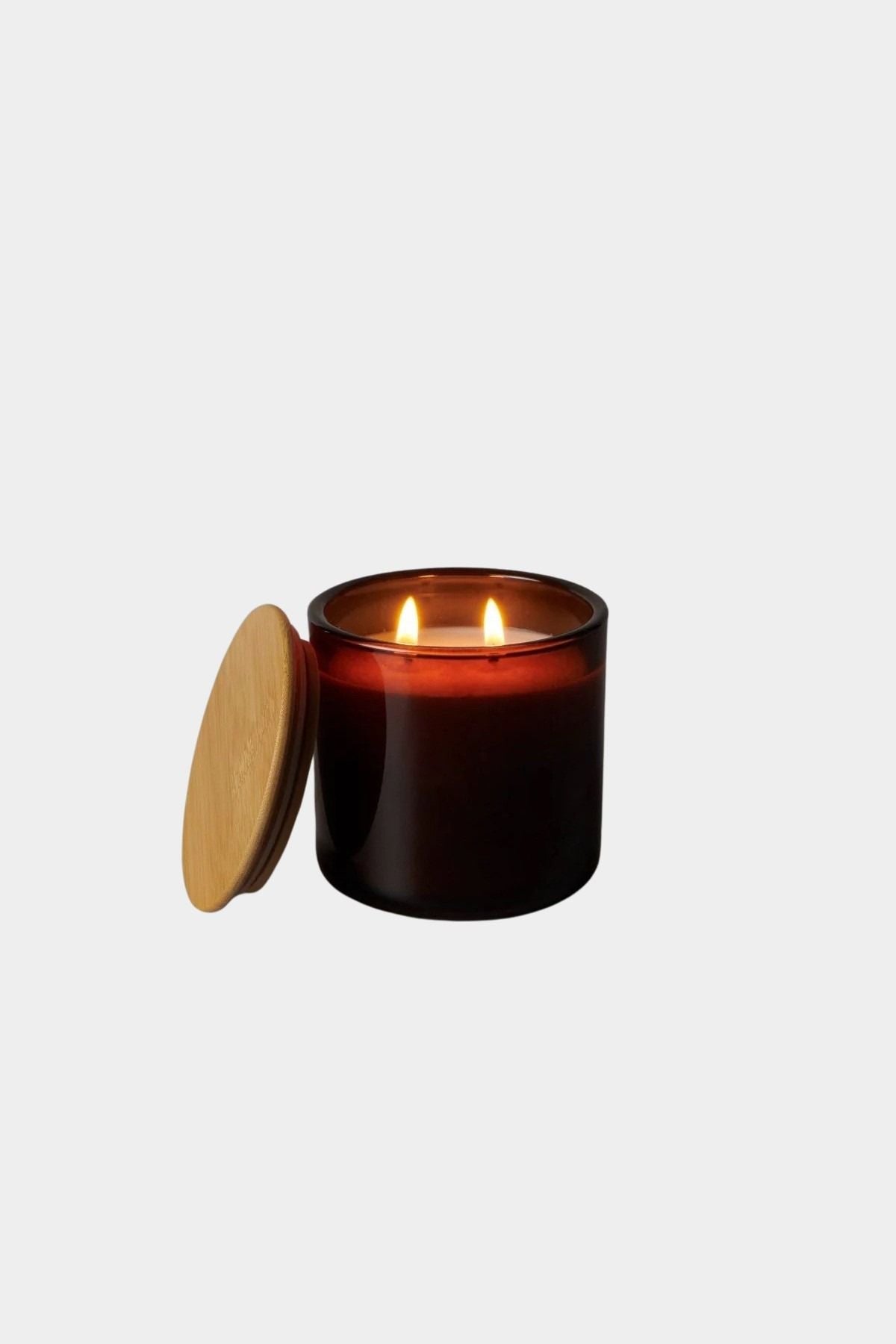 Los Poblanos Vela de la Alhucema Lavender Candle burning in amber glass vessel with wooden lid, lifestyle product image