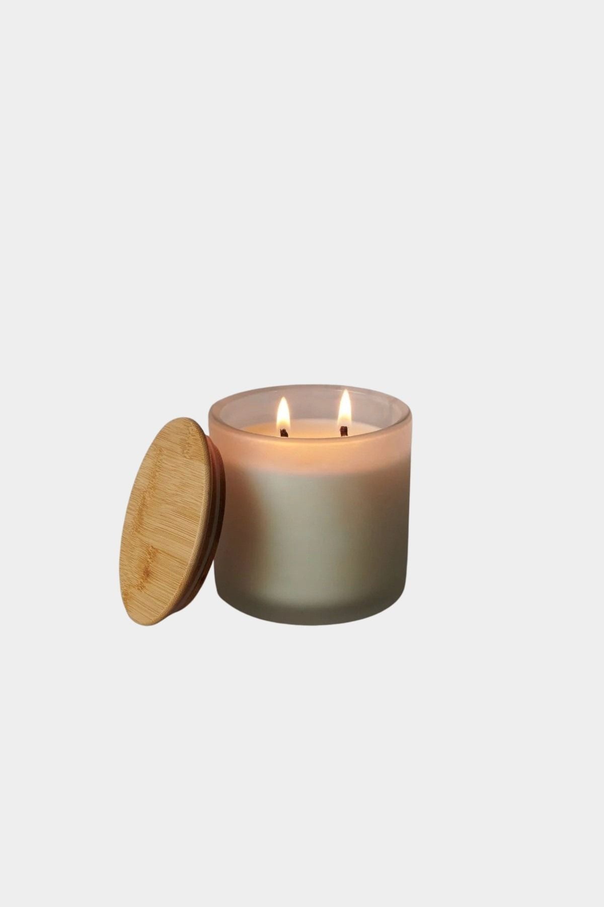 Los Poblanos Vela de la Hacienda Spa Candle with frosted glass vessel, bamboo lid, and double wick candle burning