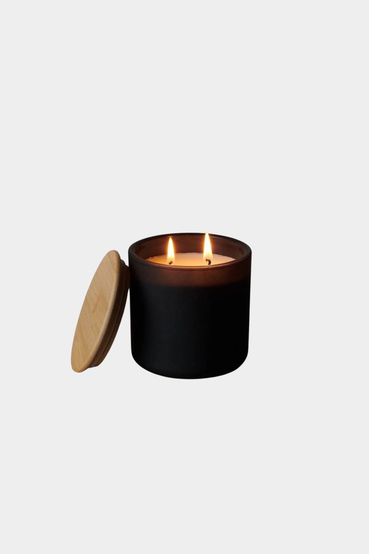 Los Poblanos Vela de la Tierra Candle with matte black vessel, bamboo lid, and double wick candle burning at YUCCA Denver boutique in Denver, Colorado
