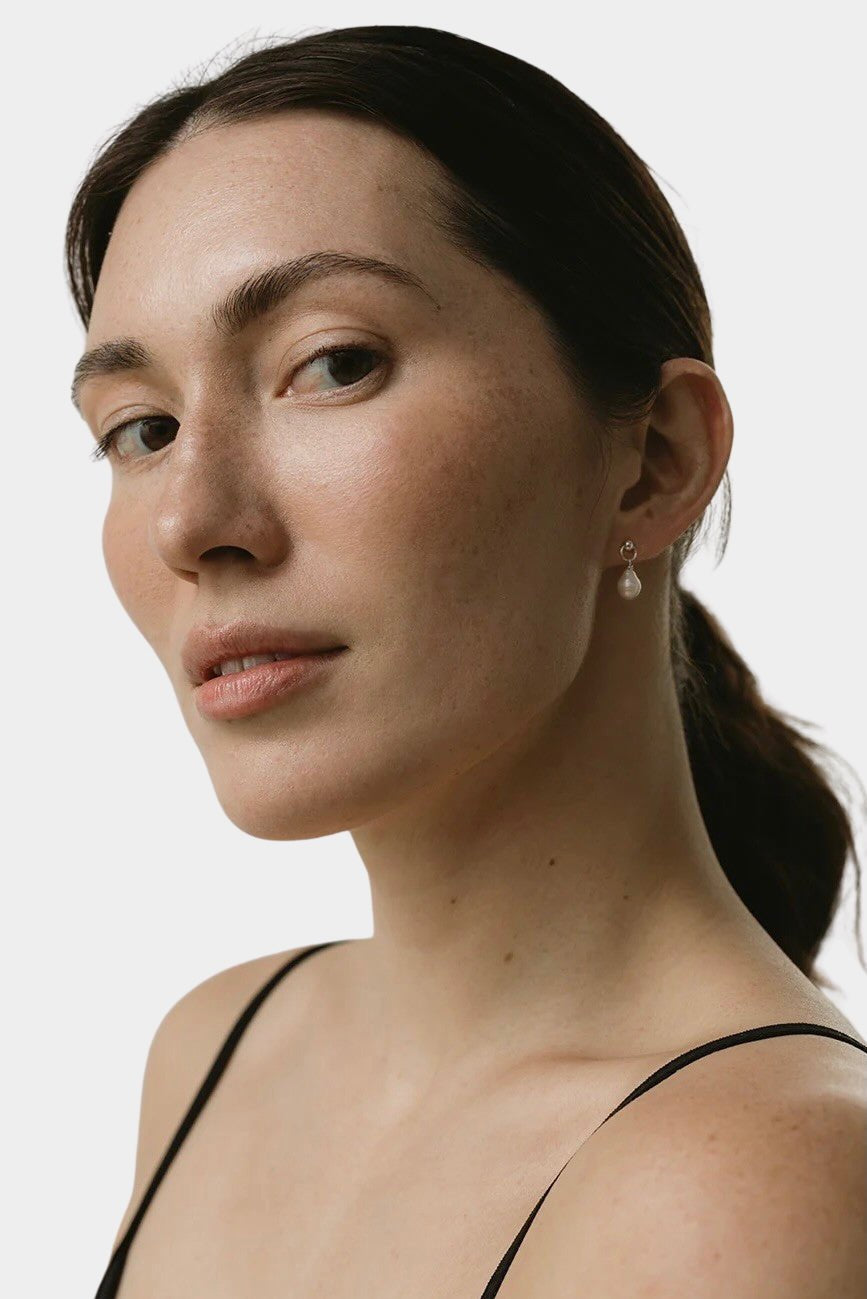 model wearing maslo balle pearl drop stud earrings sterling silver side view
