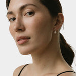 model wearing maslo balle pearl drop stud earrings sterling silver side view