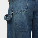 Mijeong Park blue barrel leg patch denim close up showing back pocket detail utility loop and structured cotton denim