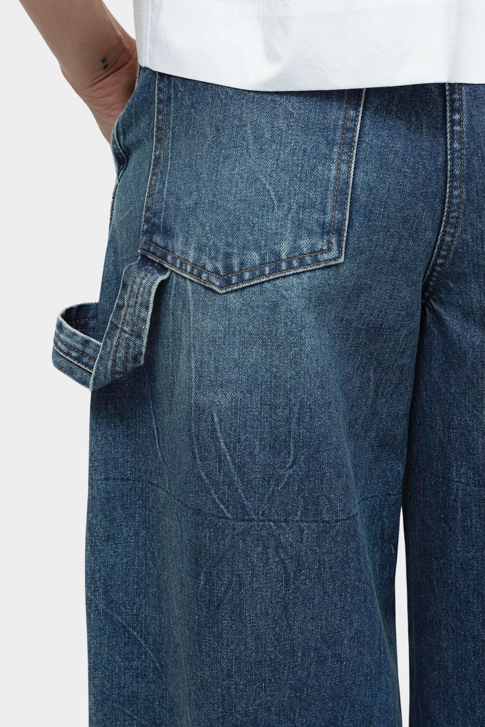 Mijeong Park blue barrel leg patch denim close up showing back pocket detail utility loop and structured cotton denim