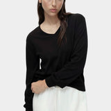 Cotton blend v neck knit top in black by Mijeong Park styled with white wide leg pants