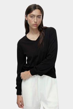 Cotton blend v neck knit top in black by Mijeong Park styled with white wide leg pants