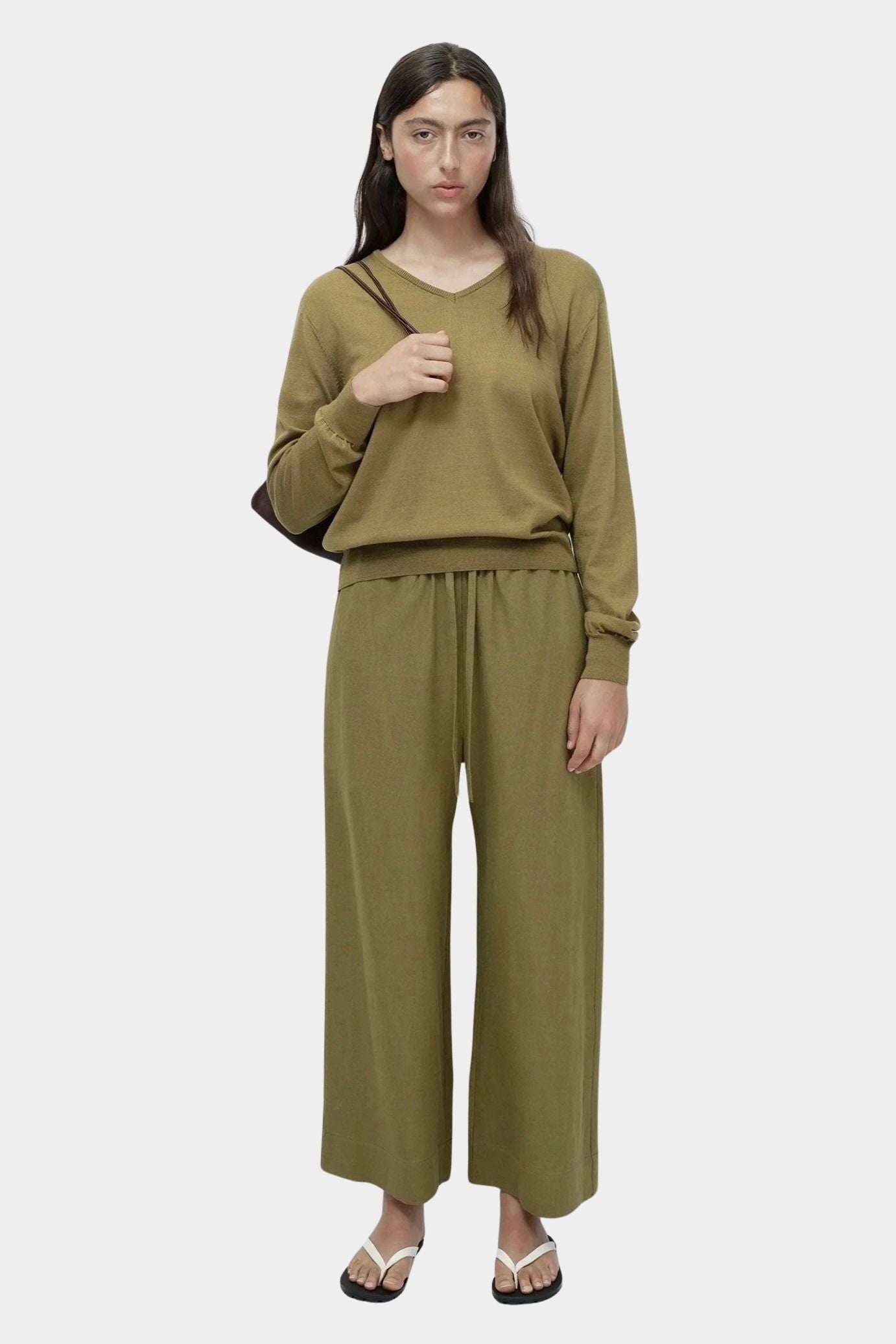 Back full view of green cotton blend v neck knit top by Mijeong Park styled with matching knit pants