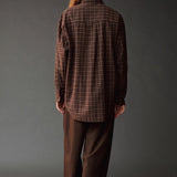 Back view of the Mijeong Park brown plaid shirt showing its oversized silhouette and curved hem