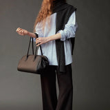 Front view of the Mijeong Park light blue oversized shirt styled with a charcoal knit and handbag