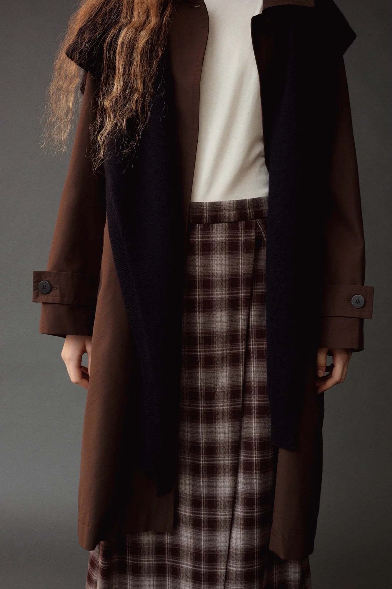 Close detail of the Mijeong Park Plaid Midi Skirt styled with a brown coat and dark scarf