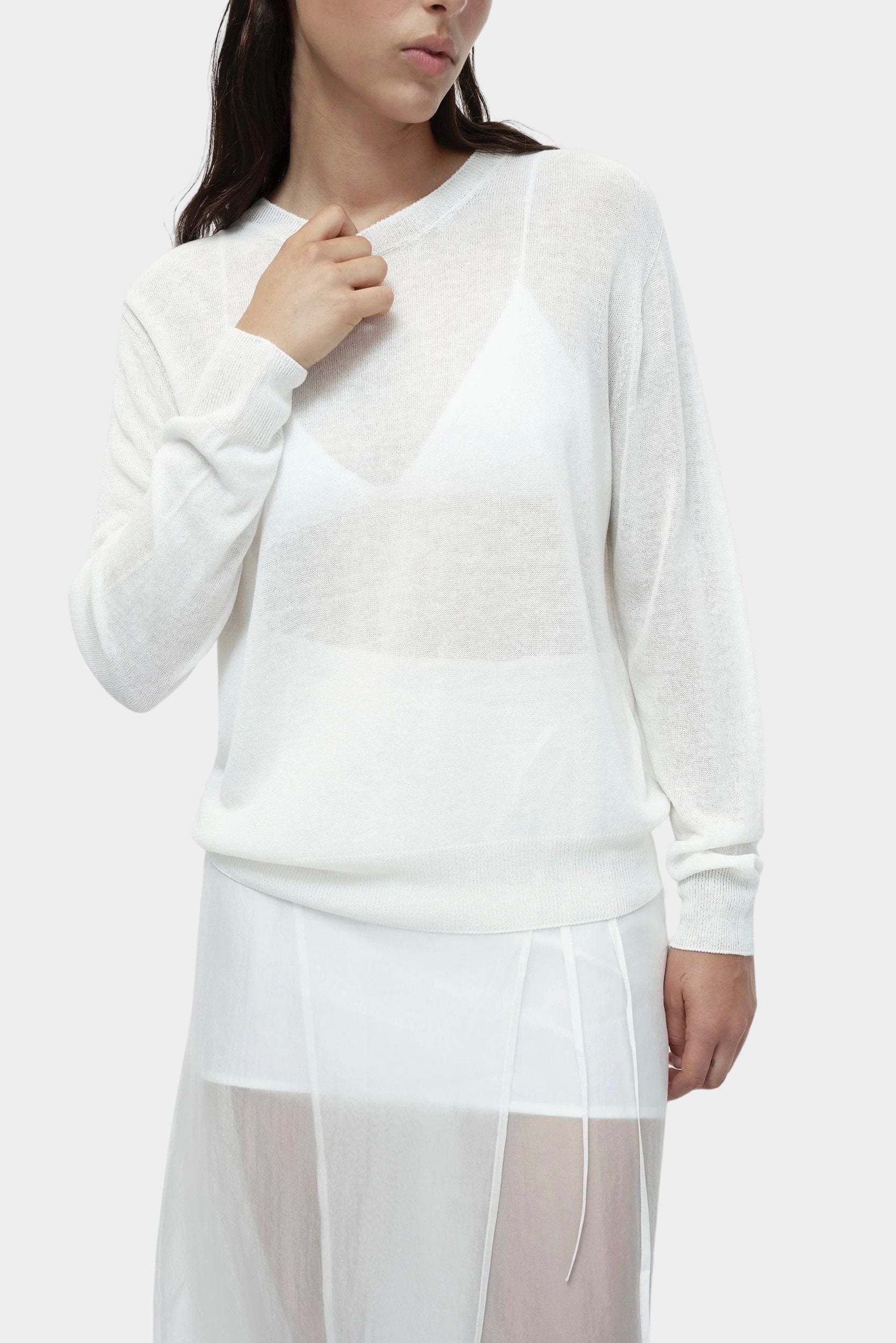 Detail of semi sheer white linen blend knit top by Mijeong Park with crew neckline and relaxed lightweight knit