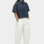 Cropped navy cotton poplin short sleeve shirt styled with relaxed cream trousers