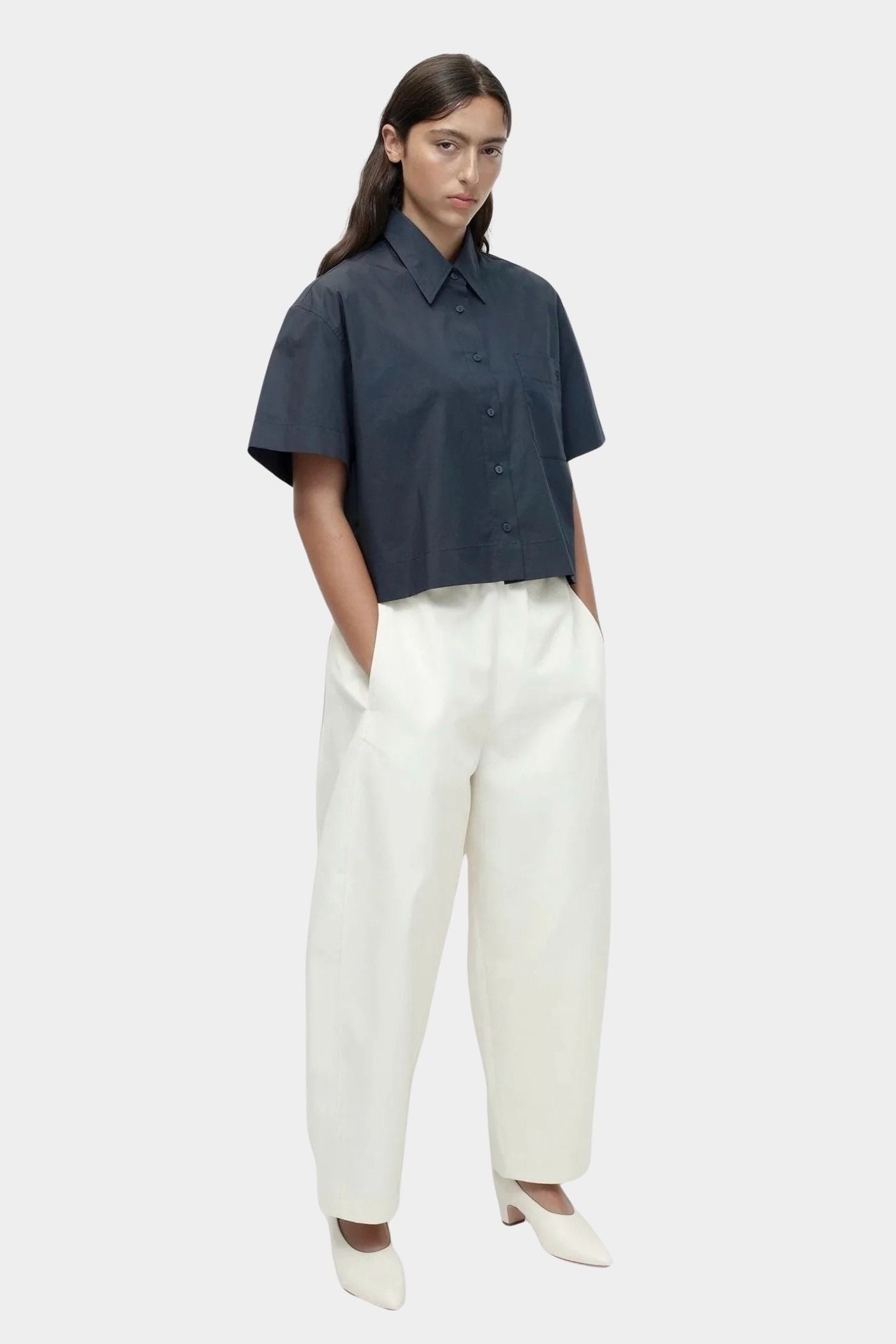 Cropped navy cotton poplin short sleeve shirt styled with relaxed cream trousers
