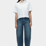 White cropped cotton poplin short sleeve shirt styled with relaxed straight leg denim