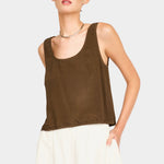 Model wearing a brown sleeveless scoop neck tank with a relaxed fit, paired with cream wide-leg pants