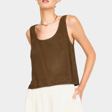 Model wearing a brown sleeveless scoop neck tank with a relaxed fit, paired with cream wide-leg pants