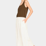 Full-body front view of brown scoop neck tank styled with cream wide-leg pants and black sandals
