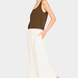 Full-body front view of brown scoop neck tank styled with cream wide-leg pants and black sandals