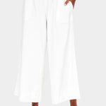 Front view of white cotton linen wide leg pants with elastic waistband and side pockets