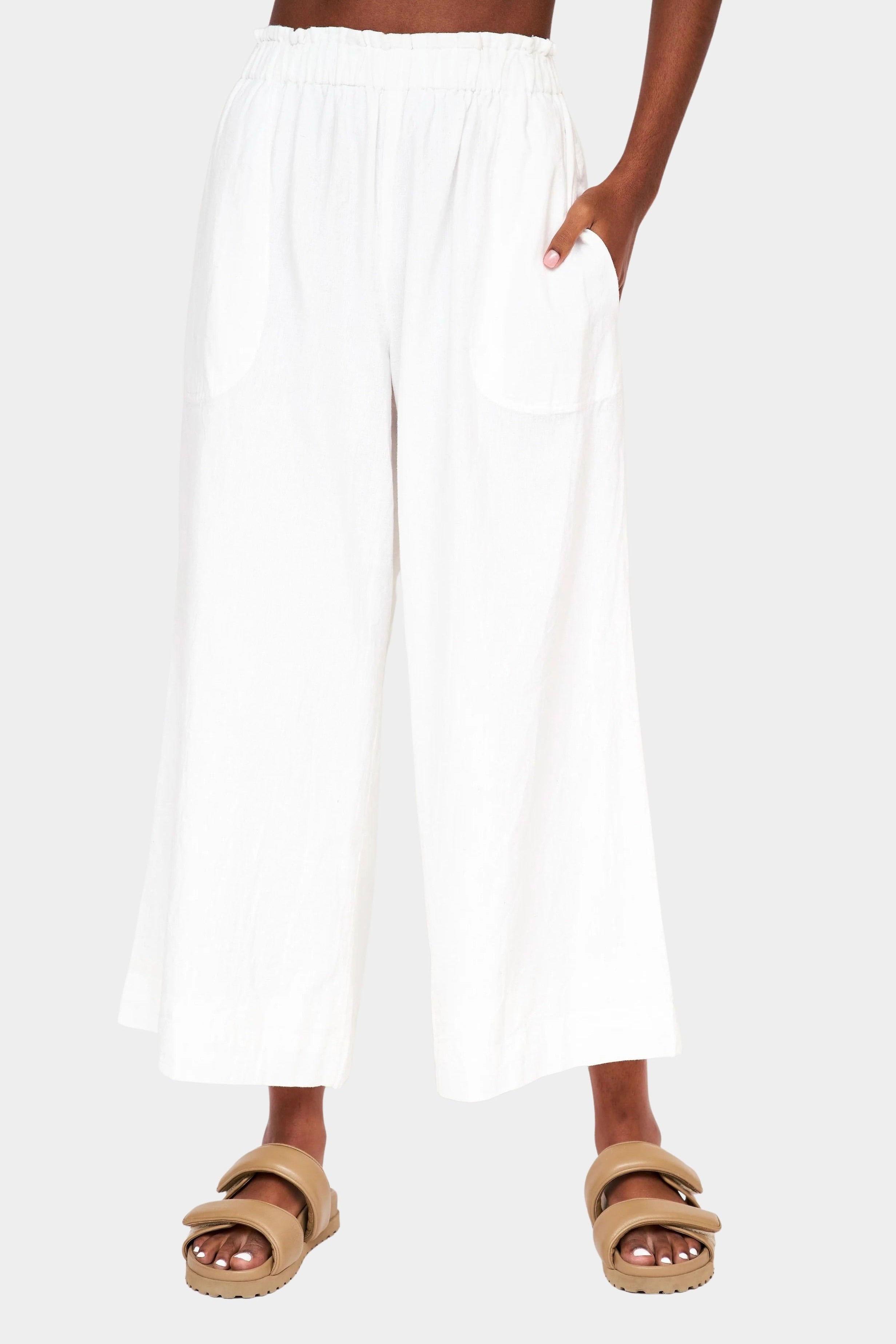 Front view of white cotton linen wide leg pants with elastic waistband and side pockets