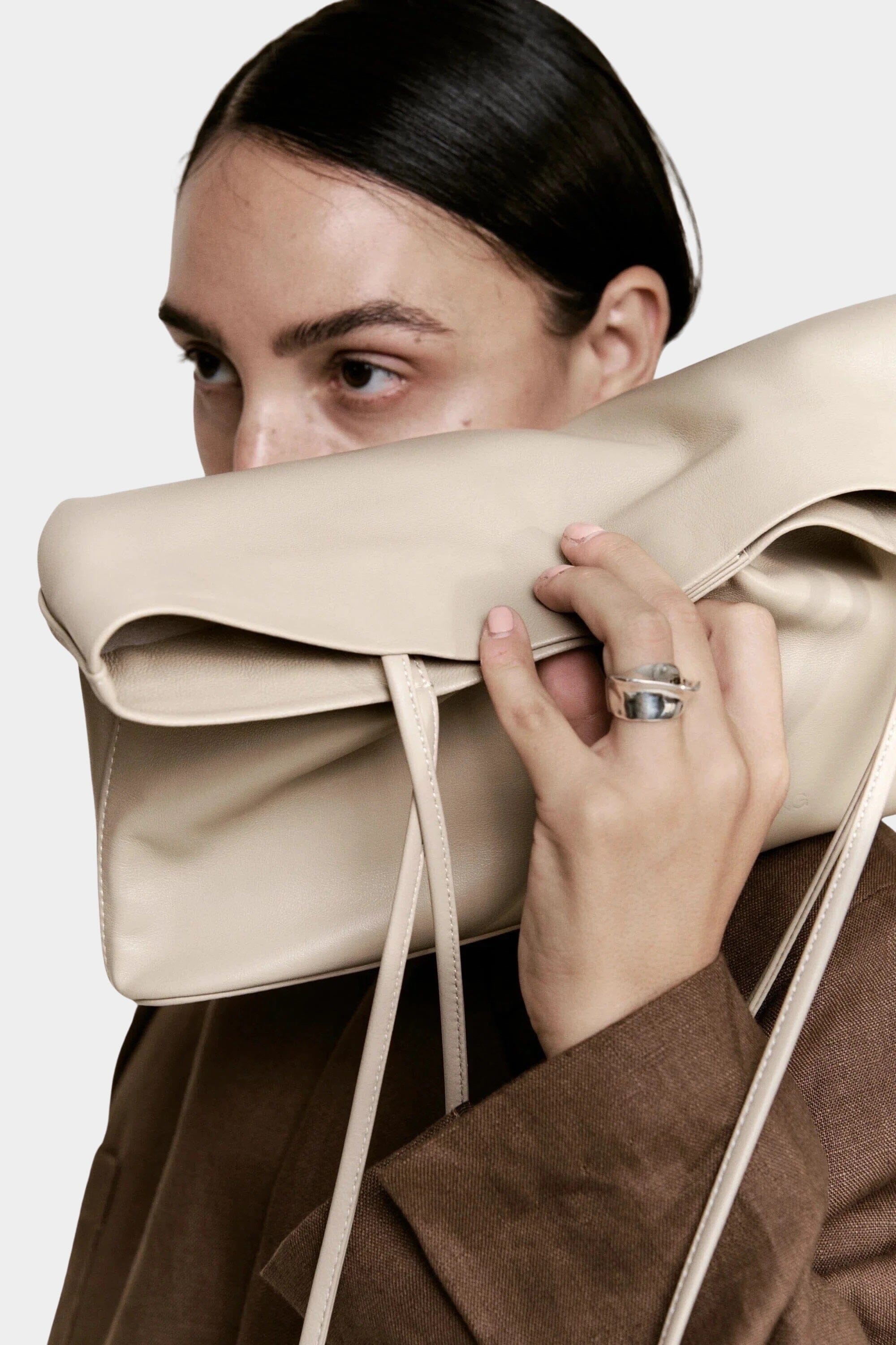Modern Weaving Narrow Oval Tote Taupe worn on shoulder showing slim vertical profile and refined shape