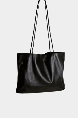 black leather narrow oval tote bag with long shoulder straps relaxed structure