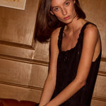 Natalie Martin Nadia Dress Black Silk Embroidery seated portrait with fluid black silk and tonal embroidery detail