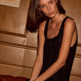 Natalie Martin Nadia Dress Black Silk Embroidery seated portrait with fluid black silk and tonal embroidery detail