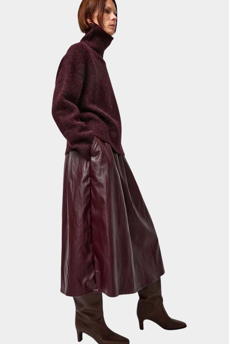 No.6 Mel Skirt in Bordeaux, side view styled with a burgundy sweater and tall boots