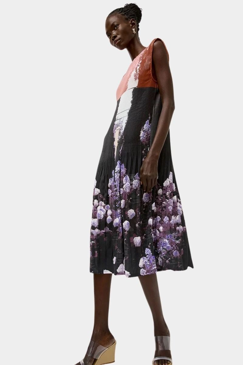 Side profile of the No.6 Tierney Dress in Eclipse with pleated texture, relaxed sleeveless fit, midi length, and dark floral photo print.