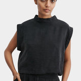 Rachel Comey Bacchus top in black with sculptural sleeveless design, structured mock neckline, and boxy cropped silhouette, styled with matching trousers