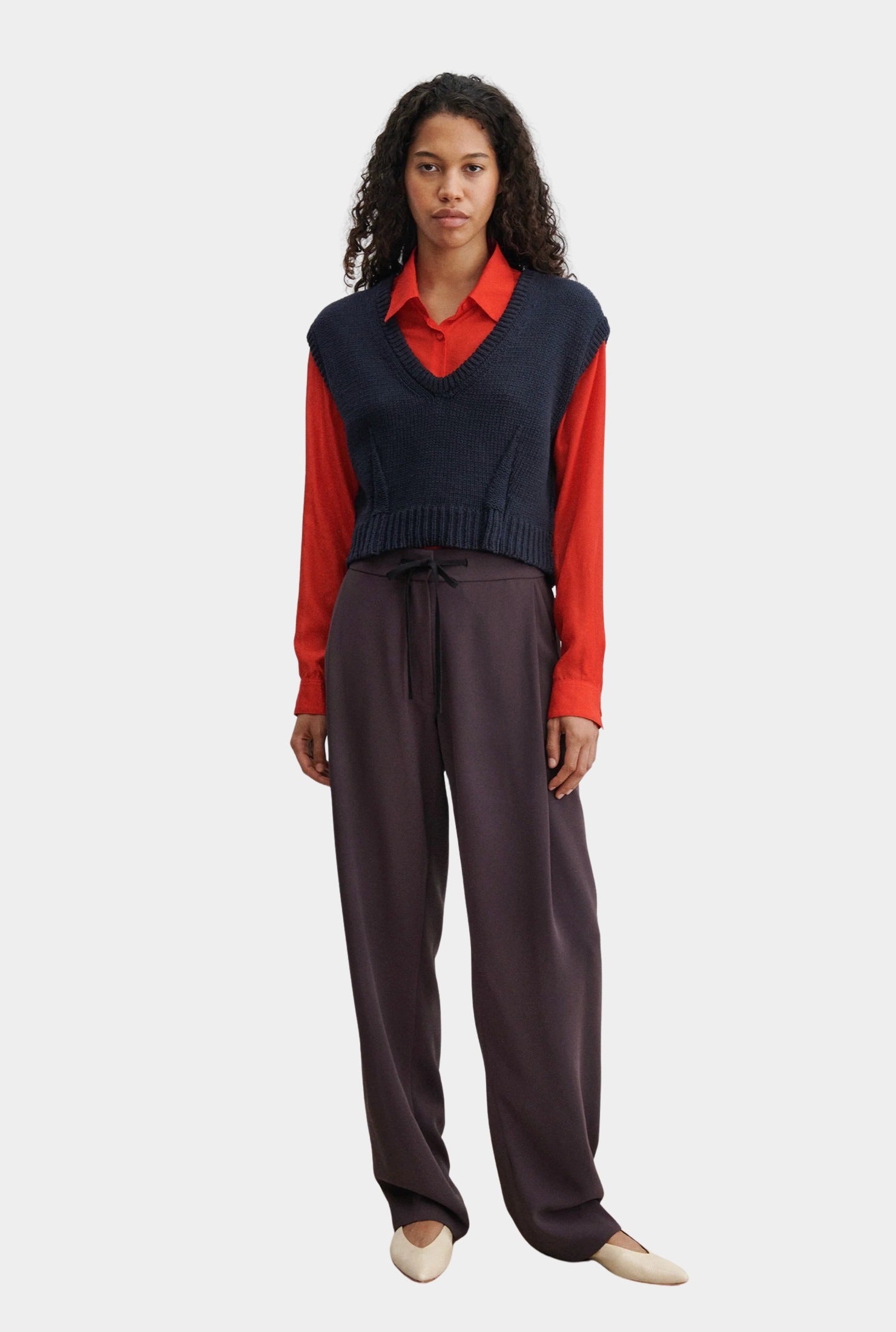 Rachel Comey navy V-neck knit vest layered styling with wide leg trousers