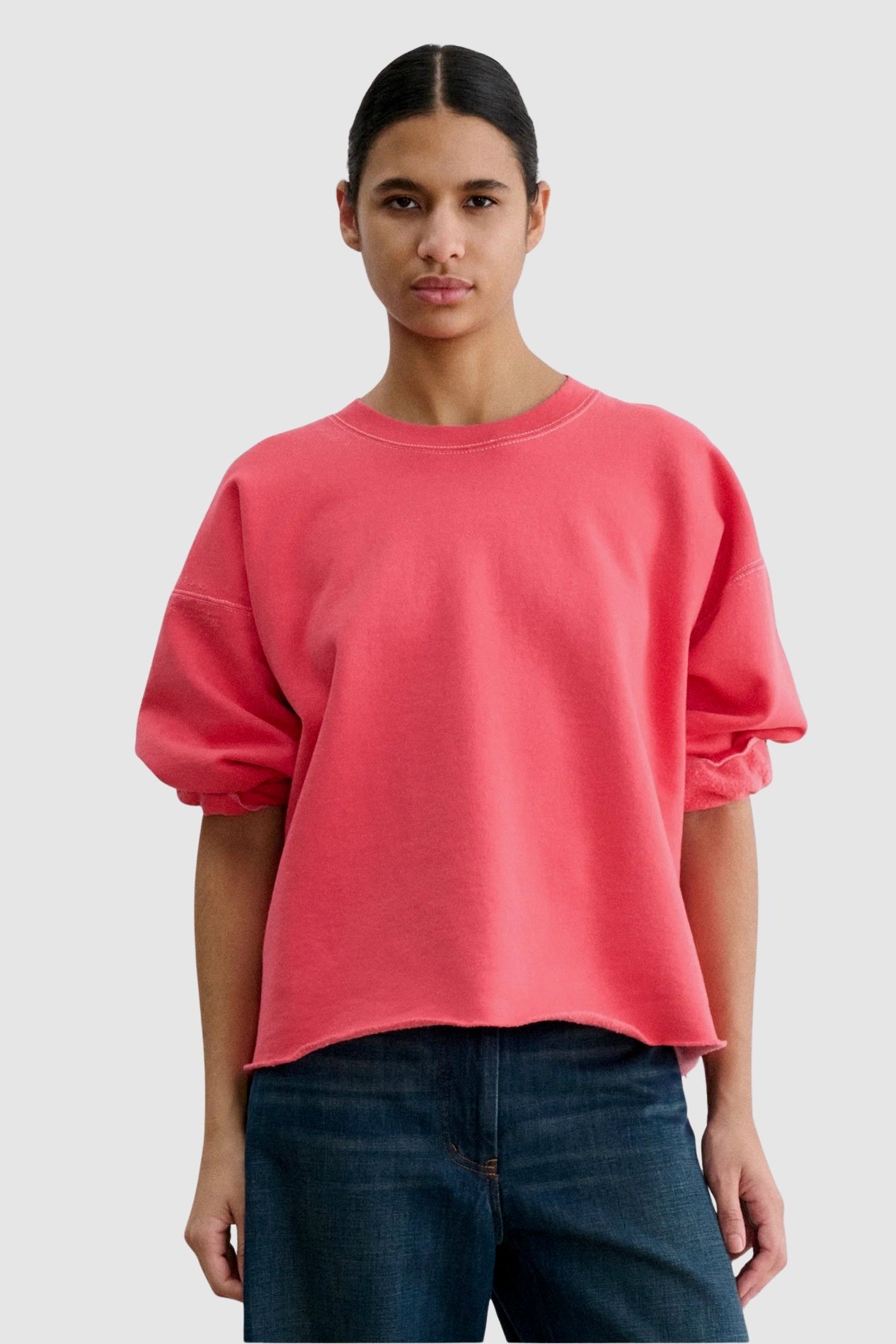 Front view of the Rachel Comey Fond Sweatshirt in Guava styled with relaxed denim