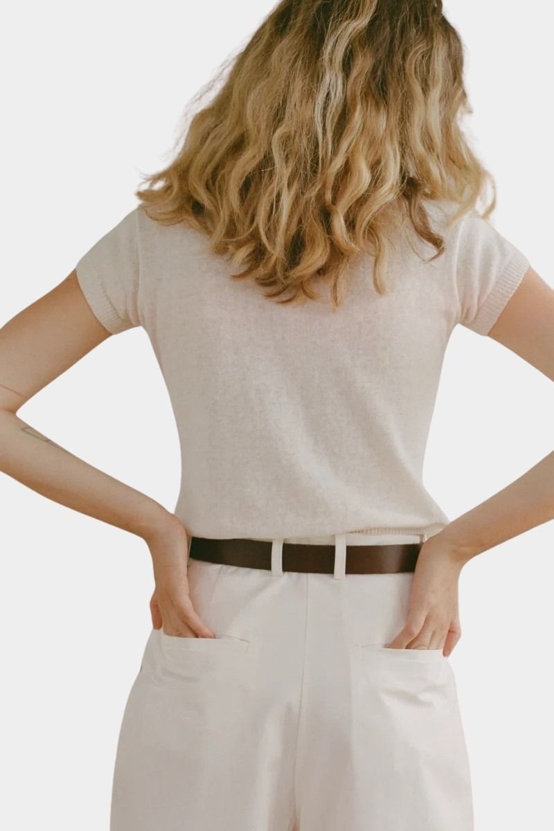 Shaina Mote Baby Tee Chalk back view fitted short sleeve knit tee styled with ivory trousers and leather belt