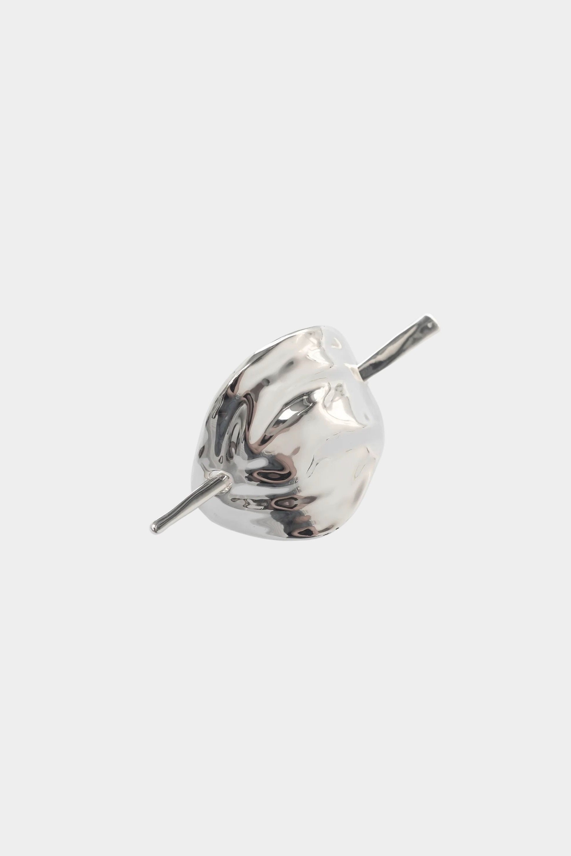 Close view sculptural silver hair pin high polish metal surface