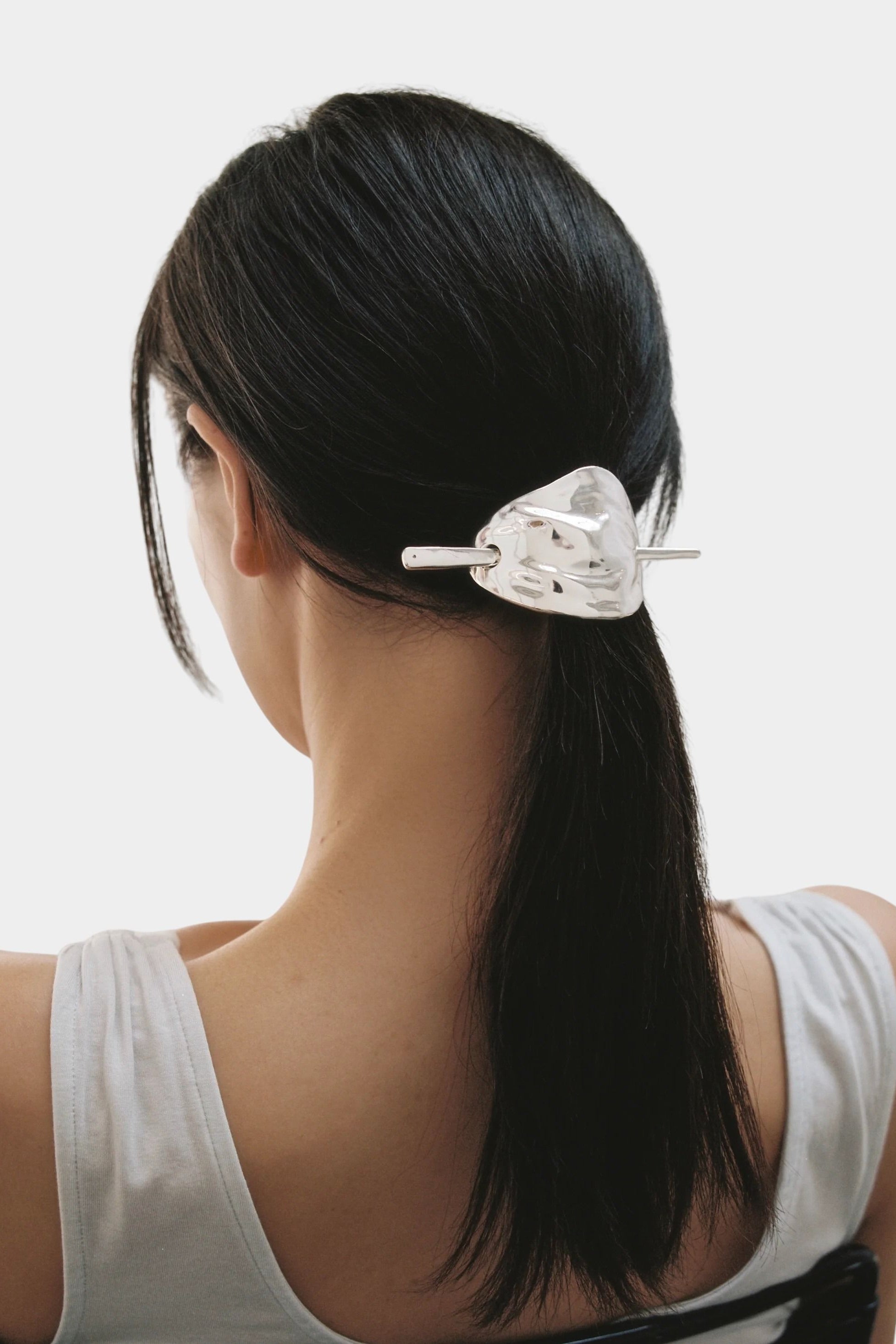 Back view silver French hair pin holding low ponytail smooth finish