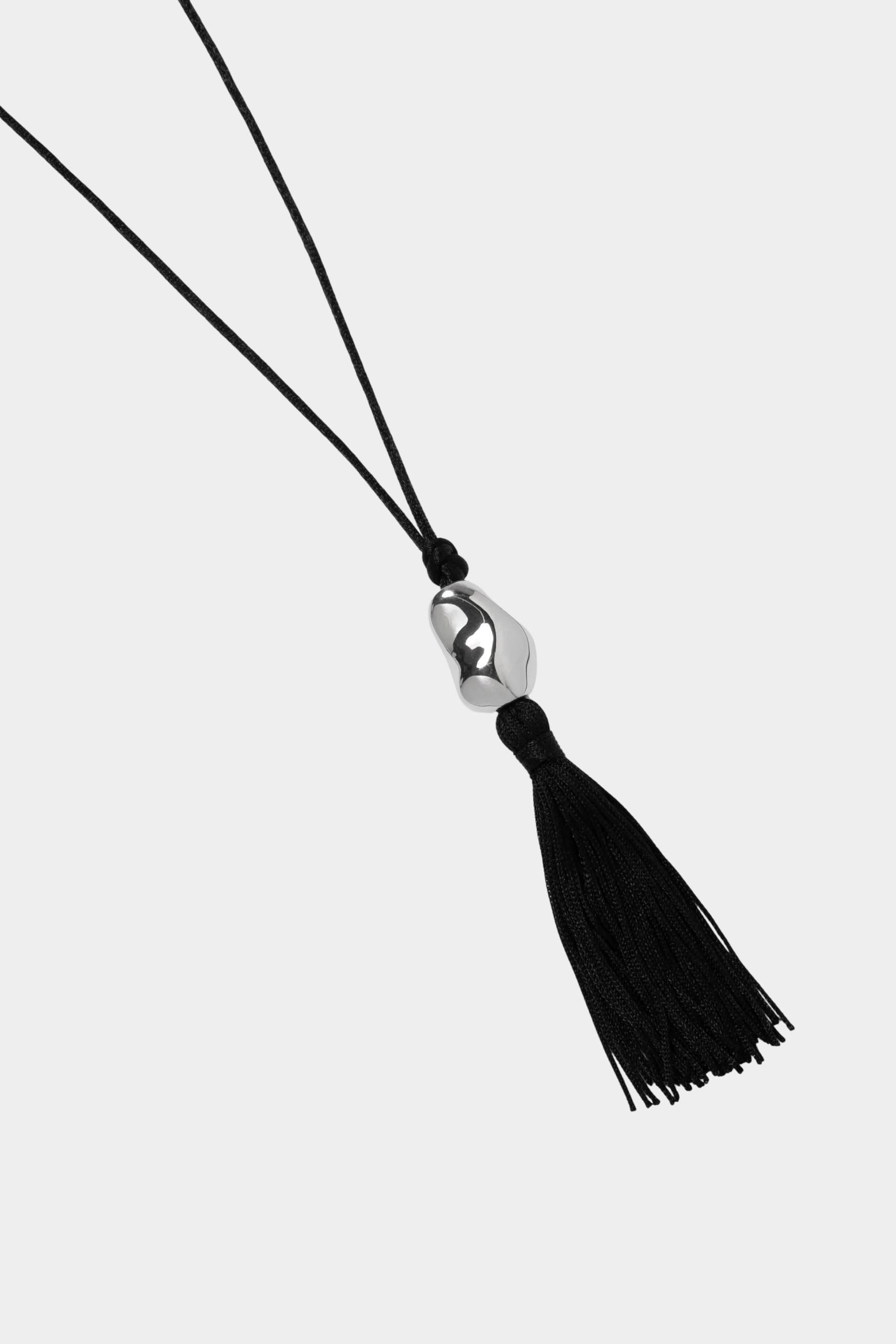 Miriam Necklace in silver Wolf Circus black cord tassel necklace flat lay sculptural pendant
