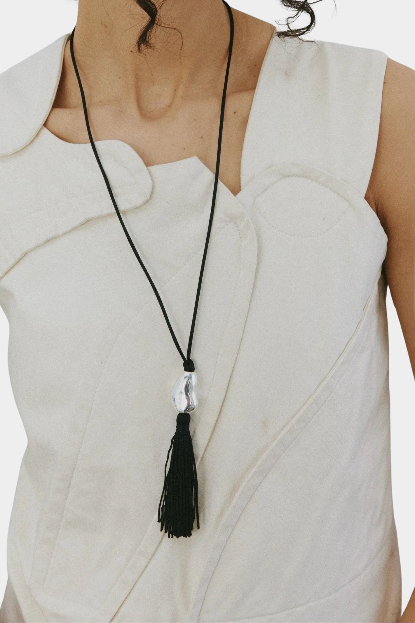 Miriam Necklace in silver Wolf Circus worn long necklace black tassel pendant on body